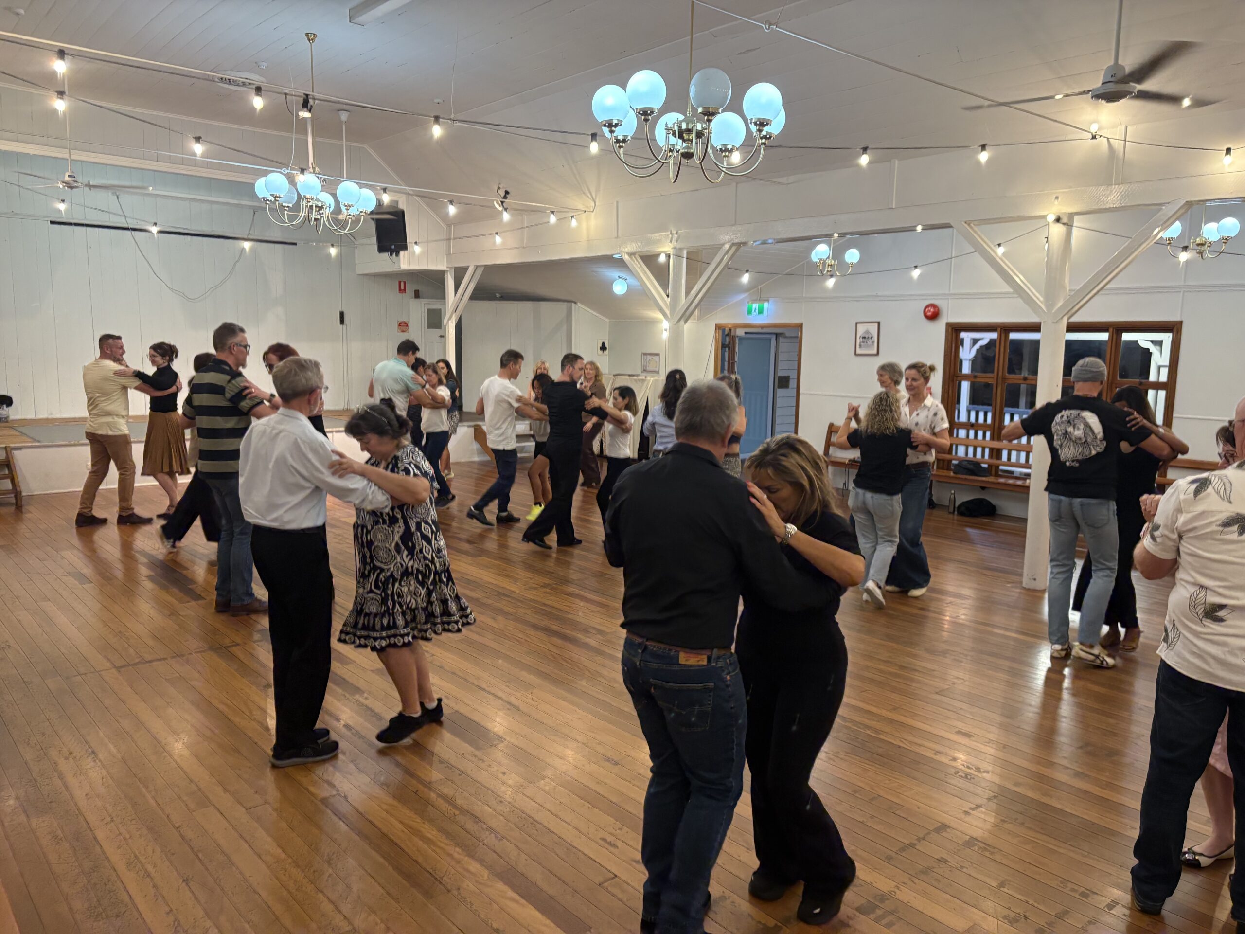 Couples enjoying dancing together inside a hall at Beyond The Steps